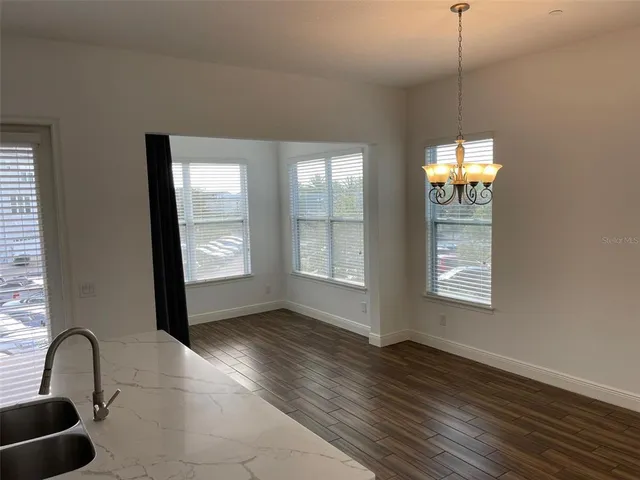 a view of an empty room with window and bathroom