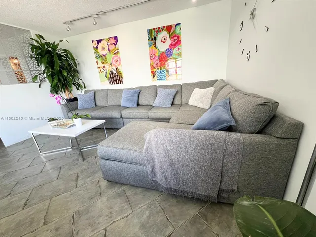 a living room with furniture and a potted plant