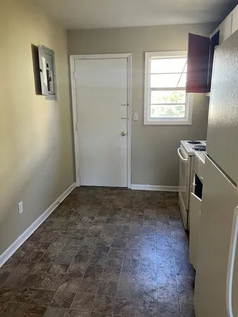 a view of a room with window and refrigerator