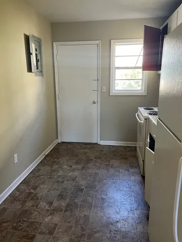 a view of a room with window and refrigerator