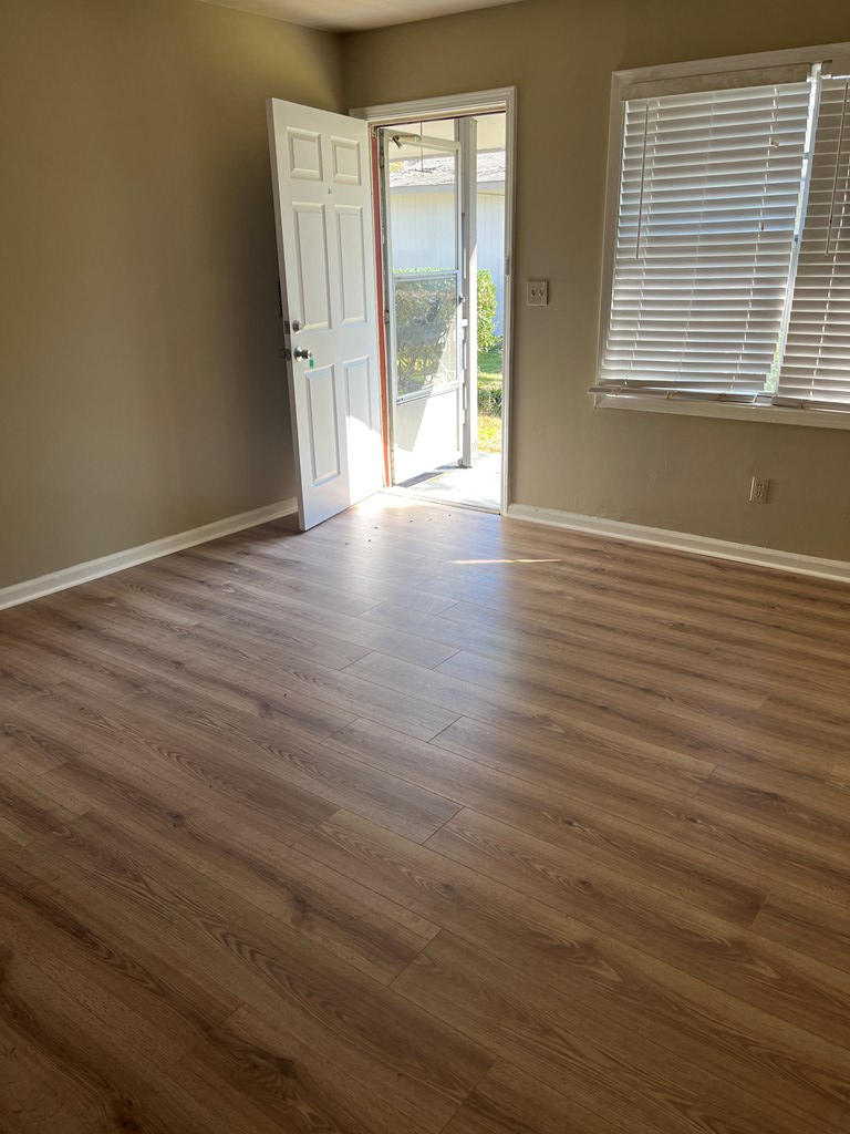 1422 23rd Street, Unit A Columbus, GA 31901 - Photo 7 of 8 a view of an empty room with wooden floor and a window