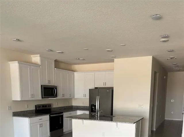 a kitchen with a refrigerator and a stove top oven