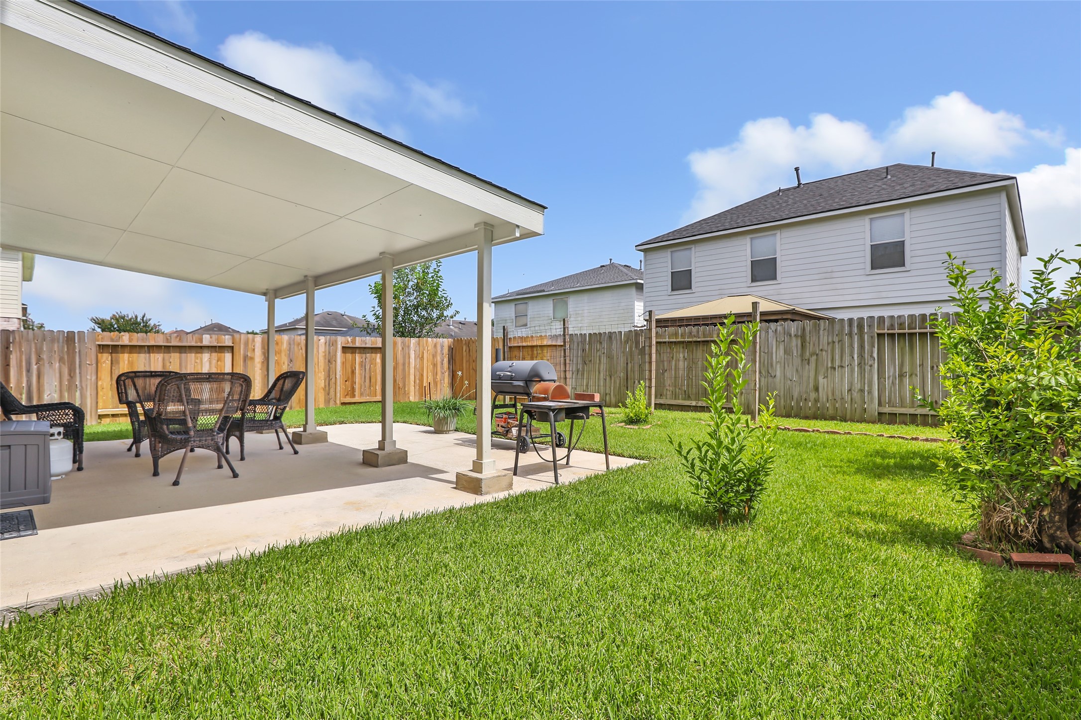 12122 Landsdown Ridge Way Humble, TX 77346 - Photo 4 of 34 This photo shows a cozy backyard with a covered patio, perfect for outdoor dining or relaxation and privacy.