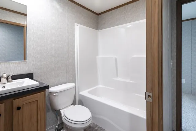 a white toilet sitting next to a bath tub