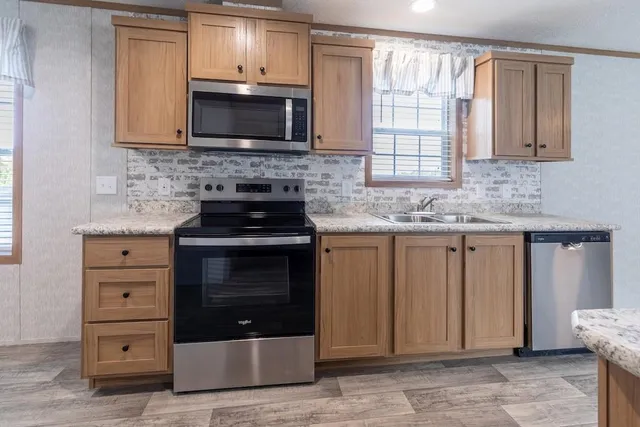 a kitchen with stainless steel appliances granite countertop a stove microwave and cabinets