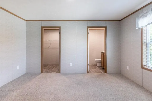 a view of empty room with windows and bathroom view