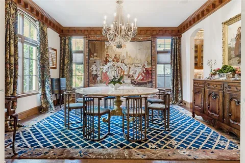 a view of a dining room with furniture a chandelier and wooden floor
