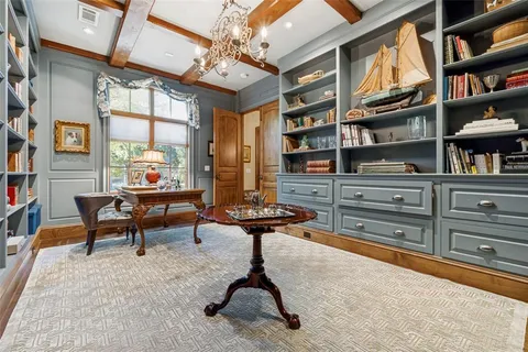 a living room with furniture a bookshelf and a window
