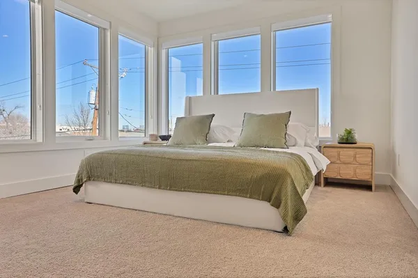 a bedroom with a bed and large window