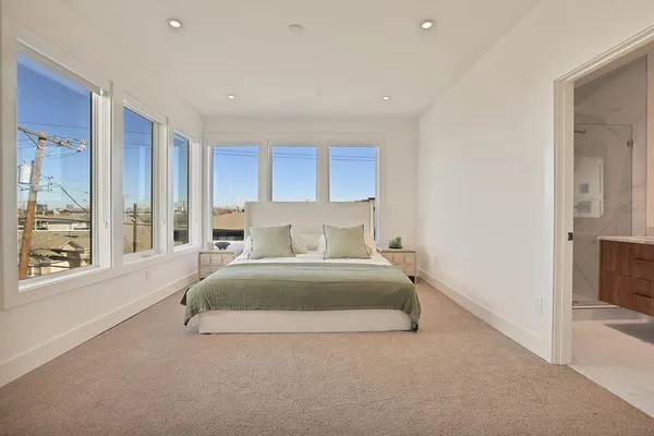 a spacious bedroom with a large bed and a large window