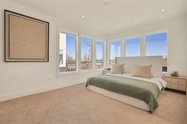 a spacious bedroom with a large bed and a large window