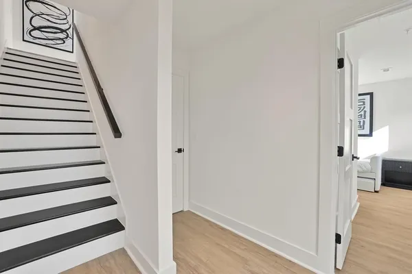 a view of a hallway with wooden floor and staircase
