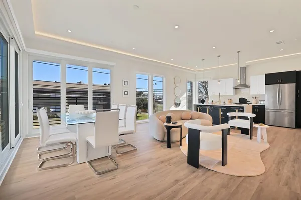 a living room with furniture a large window and wooden floor