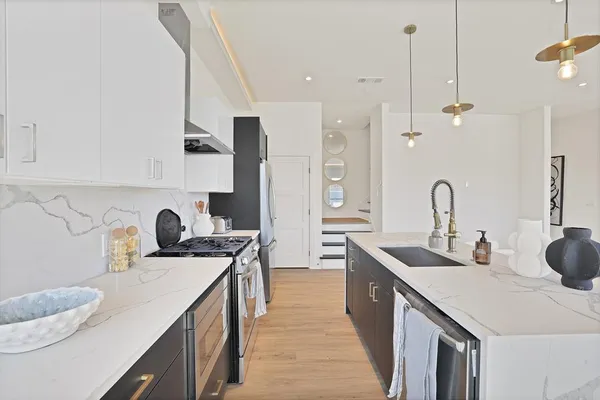 a kitchen with sink a stove and cabinets