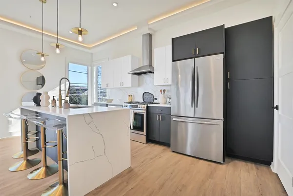 a kitchen with stainless steel appliances a refrigerator sink and cabinets