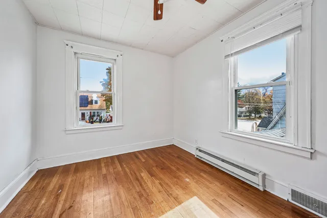 a view of a room with wooden floor and window