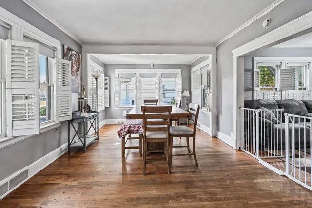 a view of a a dining room with furniture window and wooden floor