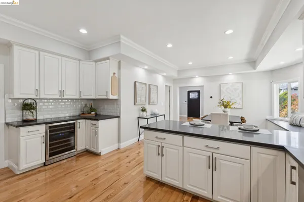 a kitchen with granite countertop white cabinets and white stainless steel appliances