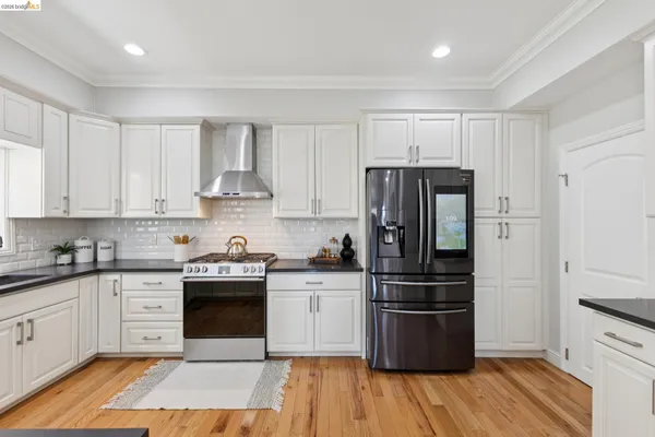 a kitchen with a refrigerator stove and wooden cabinets