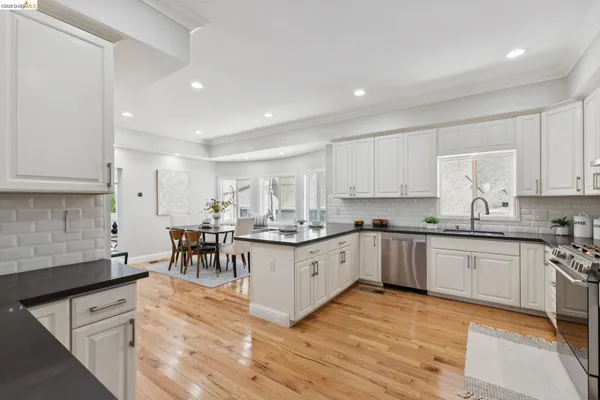 a kitchen with granite countertop refrigerator sink and cabinets