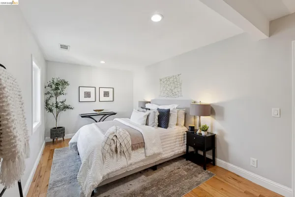 a bedroom with a large bed and a potted plant