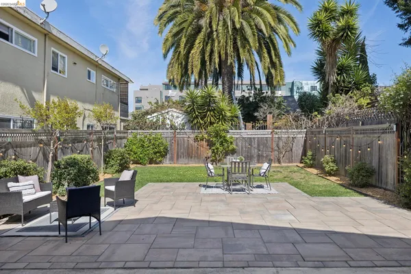 a backyard of a house with table and chairs plants