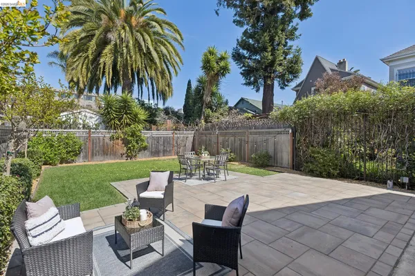 a view of a patio with table and chairs potted plants and palm tree