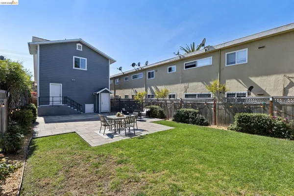 a view of a patio with a table and chairs under an umbrella