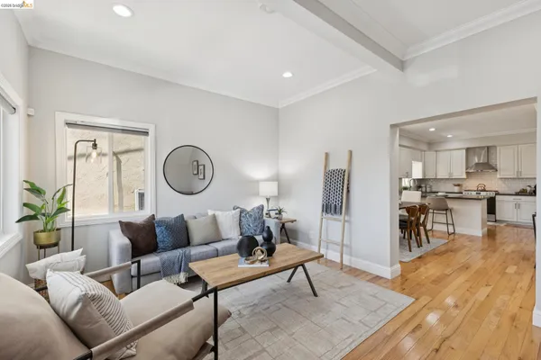 a living room with furniture a rug and kitchen view