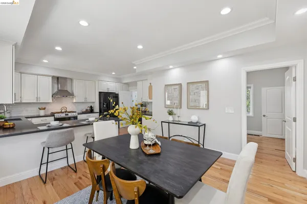 a view of a dining room and kitchen with a table chairs and wooden floor