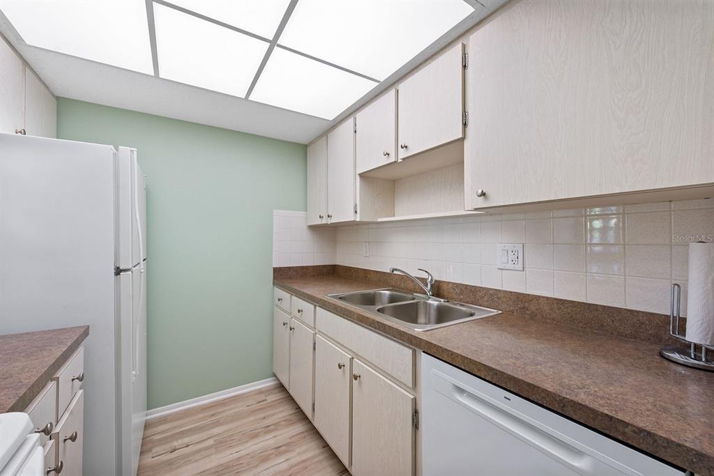 9 Quails Run Boulevard, Unit 9 Englewood, FL 34223 - Photo 11 of 42 a kitchen with stainless steel appliances granite countertop a sink and a white cabinets