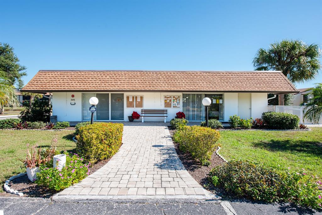 9 Quails Run Boulevard, Unit 9 Englewood, FL 34223 - Photo 31 of 42 a front view of a house with a yard