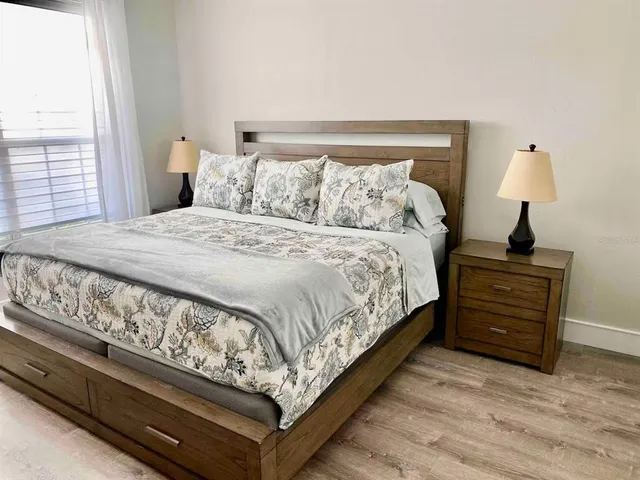 a large bed sitting in a bedroom next to a window