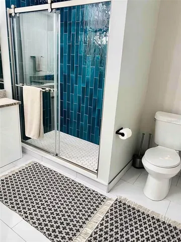 a bathroom with a toilet and a shower