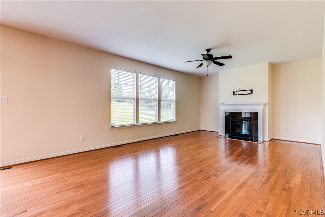 14513 Needham Market Road Midlothian, VA 23112 - Photo 3 of 31 an empty room with wooden floor fireplace and windows