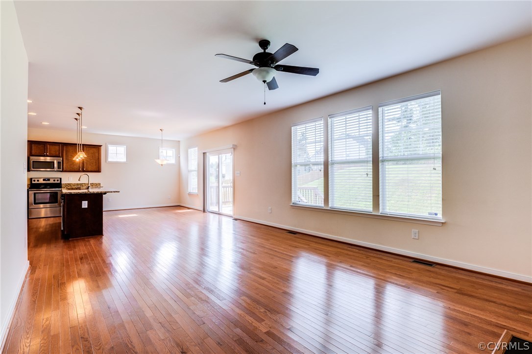 14513 Needham Market Road Midlothian, VA 23112 - Photo 4 of 31 a view of an empty room with a kitchen and wooden floor