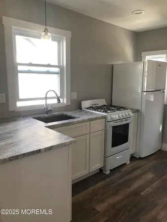 a kitchen with a stove window and refrigerator