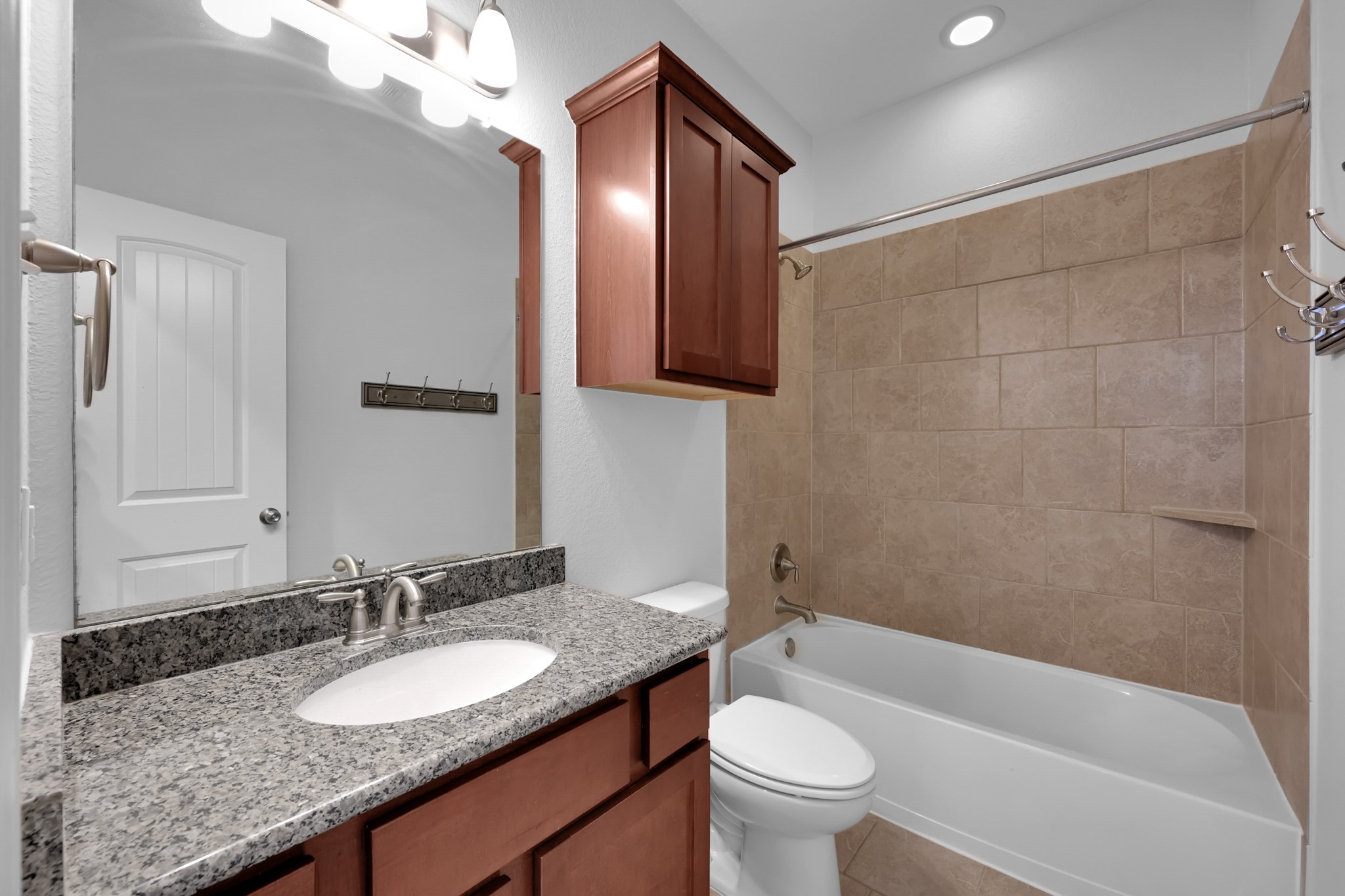 31851 Chapel Rock Lane Spring, TX 77386 - Photo 29 of 50 a bathroom with a granite countertop sink a toilet a mirror a bathtub and shower