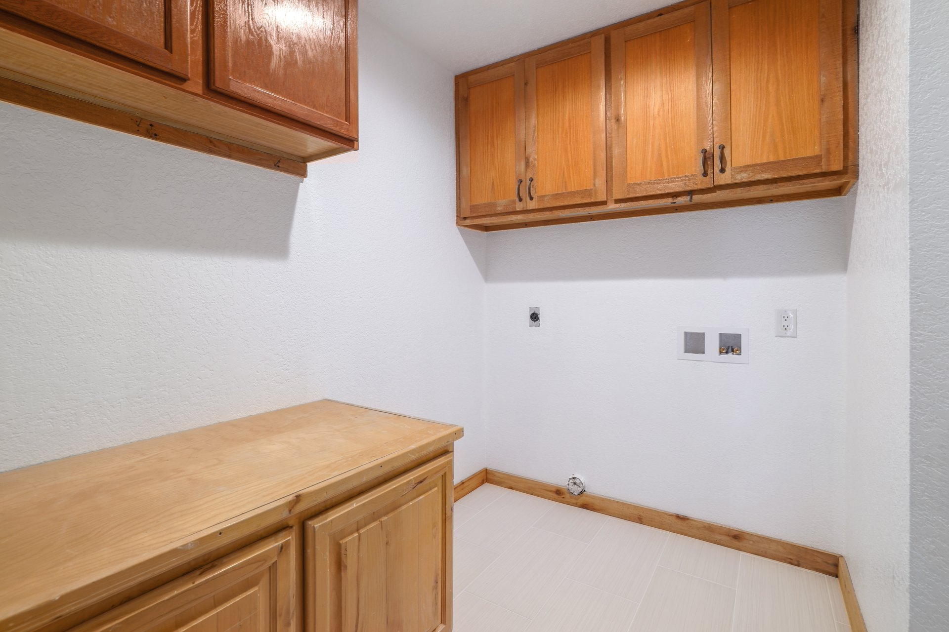 313 Kendall Road Spicewood, TX 78669 - Photo 23 of 34 Laundry area with cabinet space, hookup for an electric dryer, washer hookup, and a textured wall