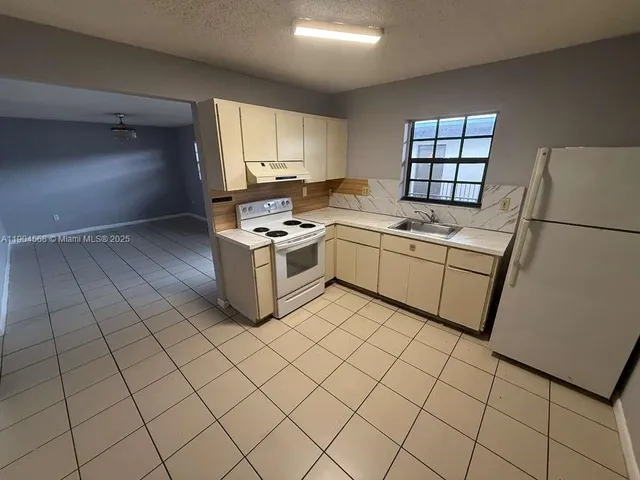 a kitchen with stainless steel appliances a stove a sink and a refrigerator