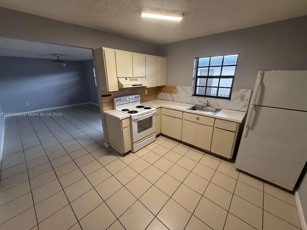 a kitchen with stainless steel appliances a stove a sink and a refrigerator