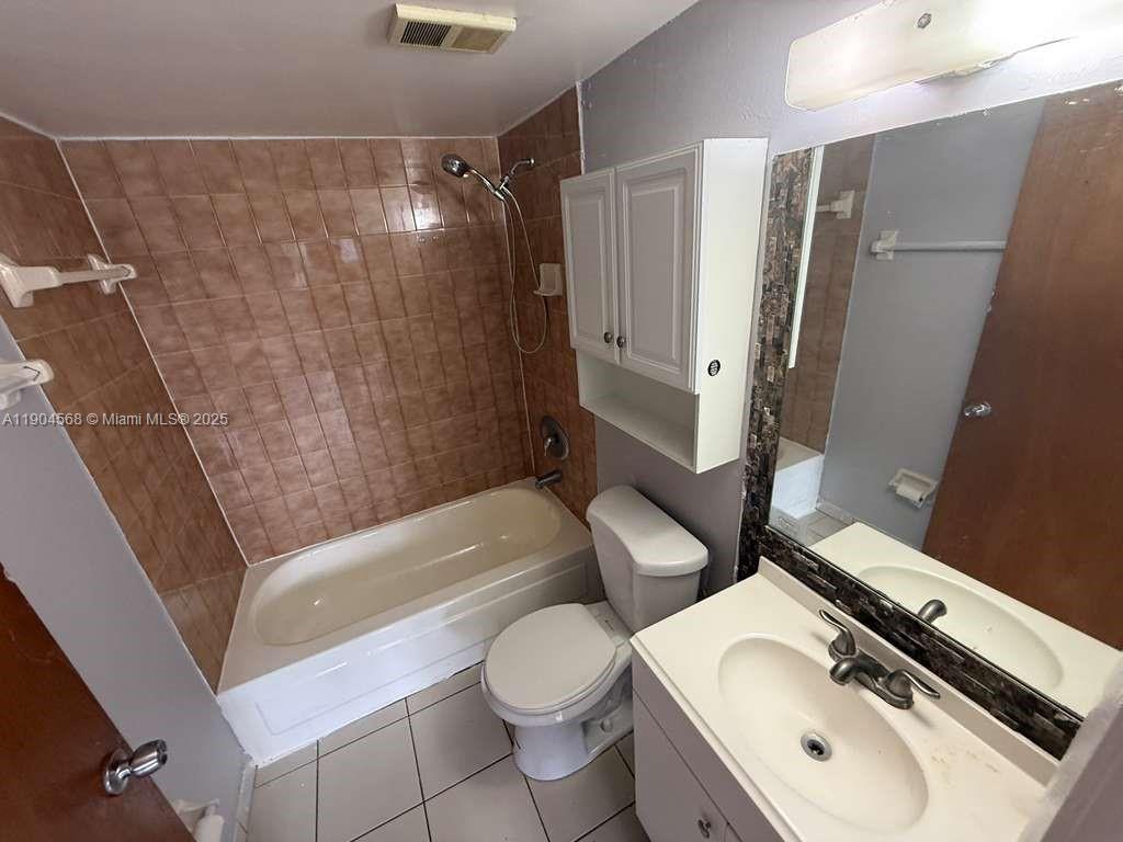 335 West 68th Street, Unit 201 Hialeah, FL 33014 - Photo 7 of 8 a bathroom with a sink a toilet and shower