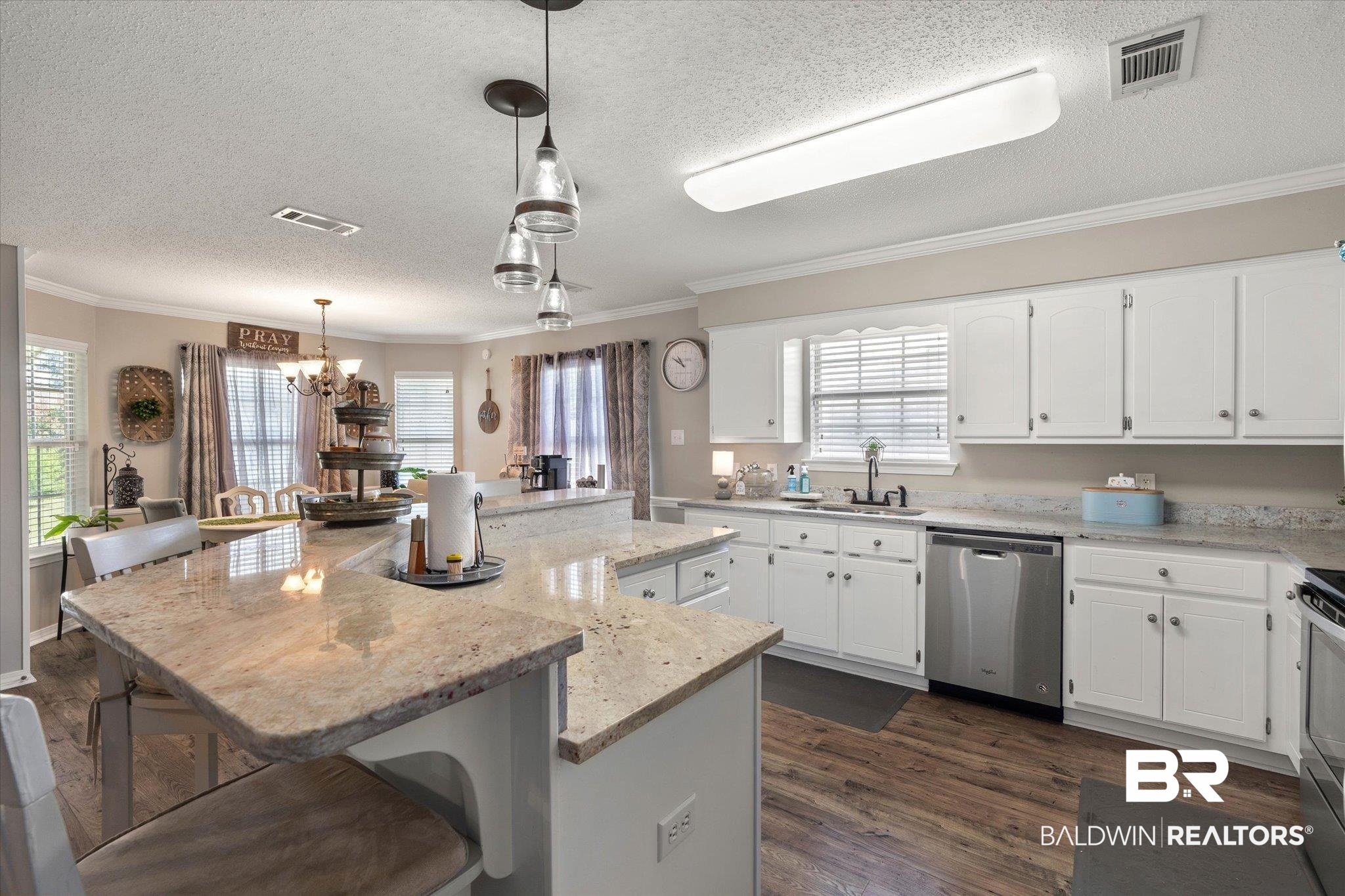 8600 Sable Court Semmes, AL 36575 - Photo 5 of 20 Kitchen featuring stainless steel appliances, a center island, a textured ceiling, a chandelier, and white cabinets