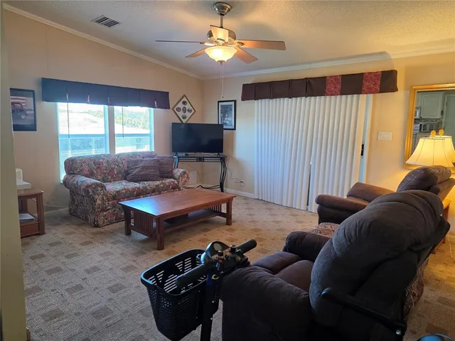 a living room with furniture a ceiling fan and a window
