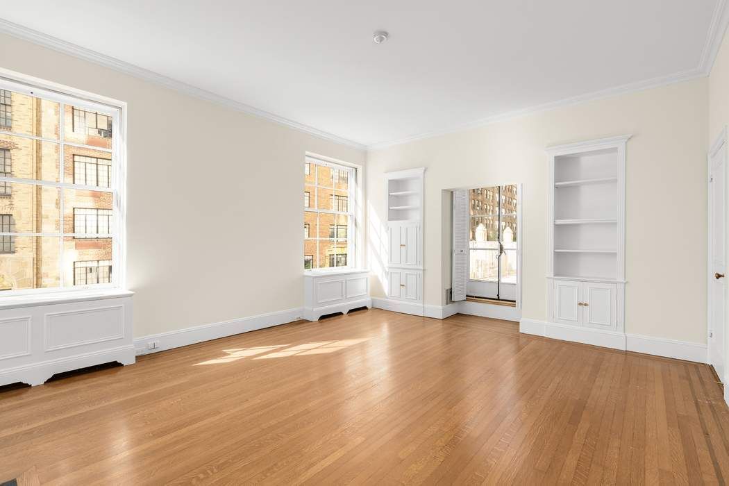 435 East 52nd Street, Unit 3A Manhattan, NY 10022 - Photo 30 of 35 an empty room with wooden floor and windows