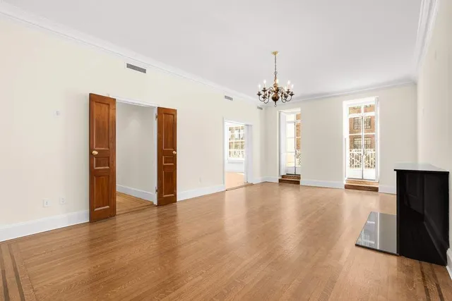 a view of an empty room with a fireplace and a window