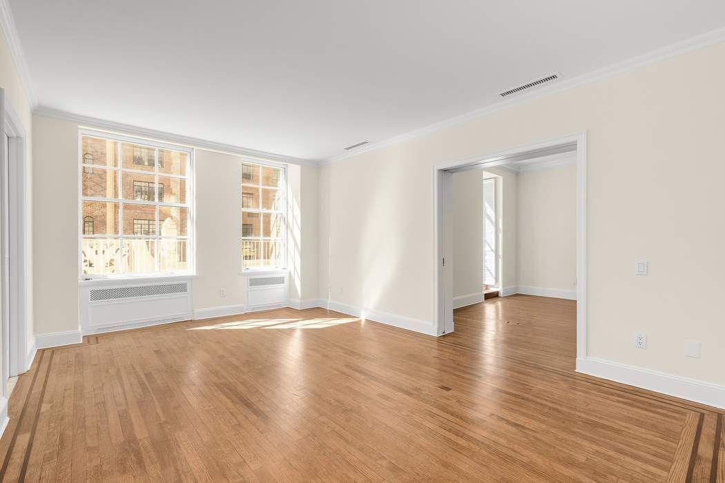 435 East 52nd Street, Unit 3A Manhattan, NY 10022 - Photo 33 of 35 an empty room with wooden floor and windows