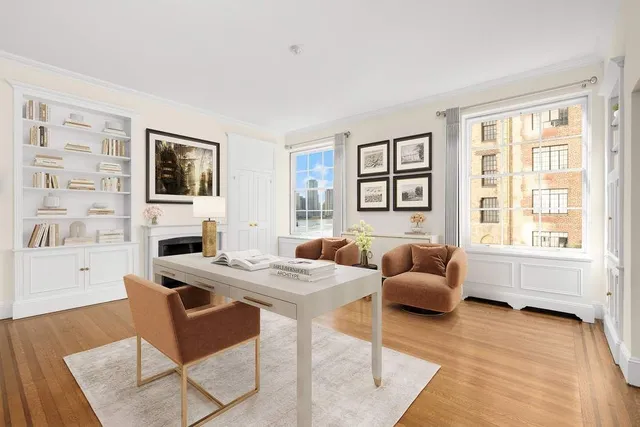 a living room with furniture large windows and wooden floor