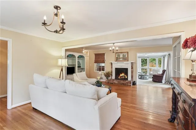 a living room with furniture a fireplace and a chandelier