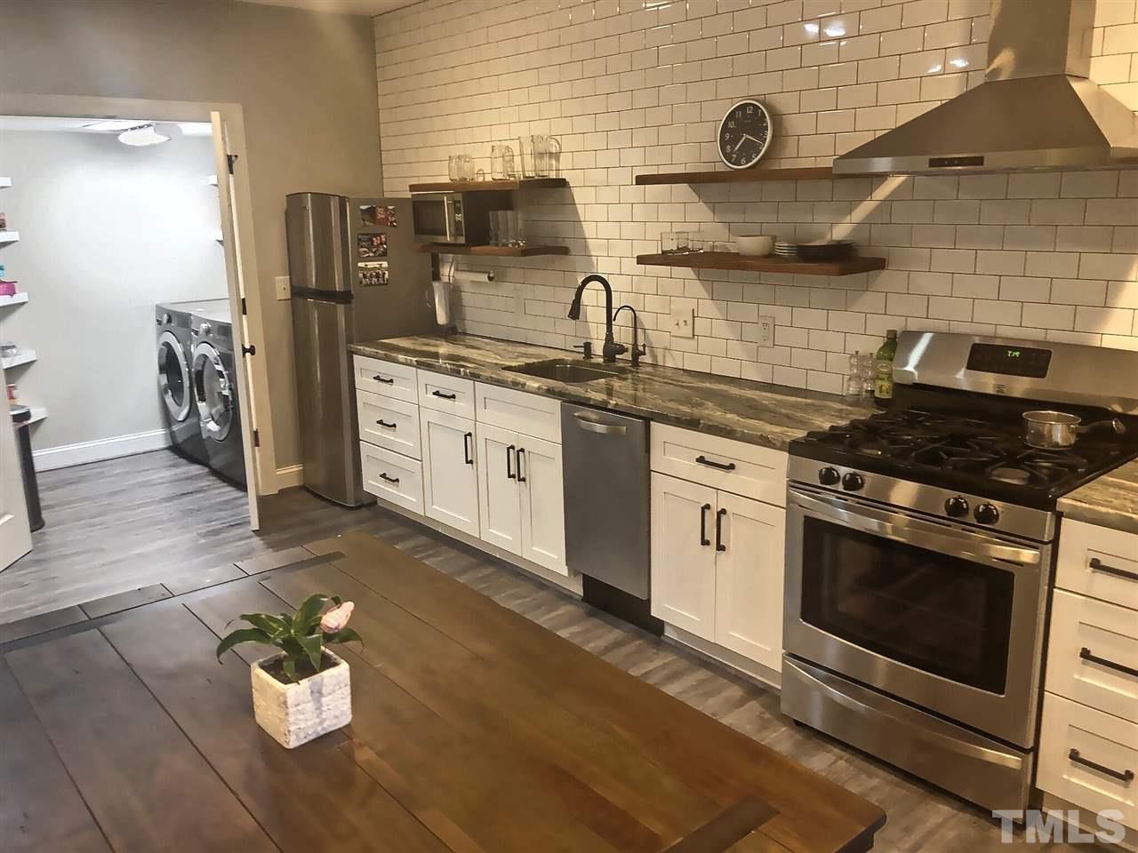 9328 Tabriz Point Raleigh, NC 27614 - Photo 22 of 29 a kitchen with stainless steel appliances a stove a sink and white cabinets